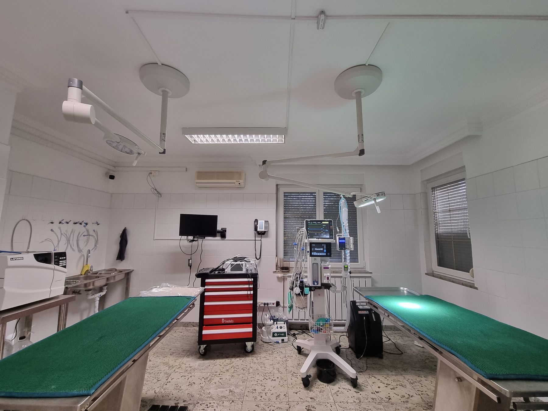 Fully equipped surgical theatre with ceiling-mounted lighting and anaesthesia station